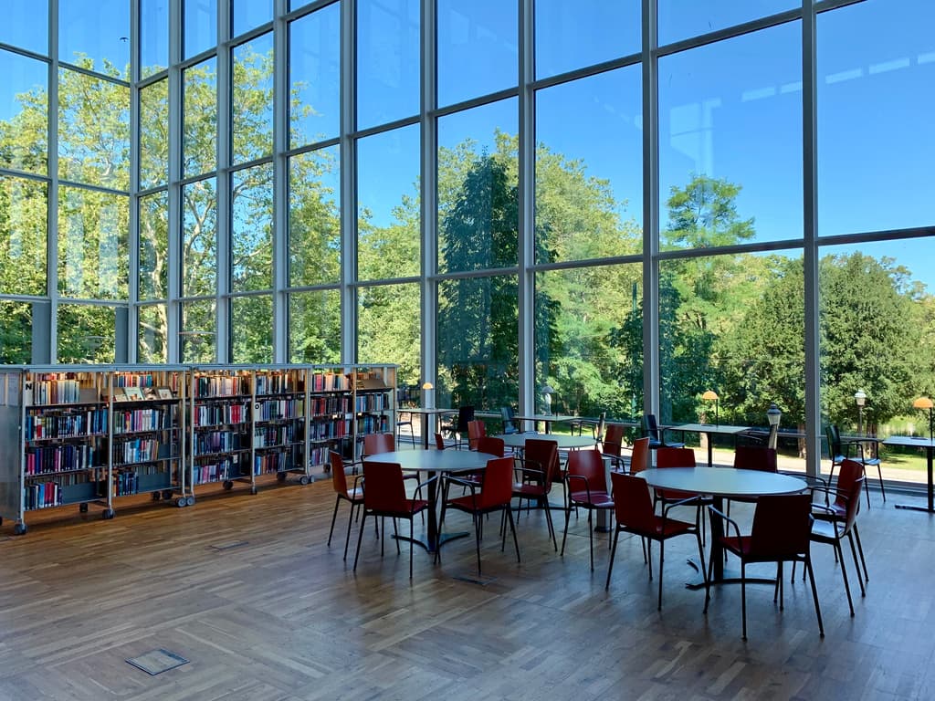 a photo of a library with couple of desks and tables